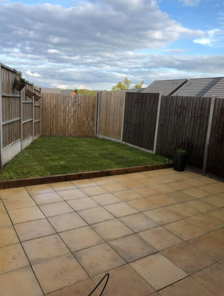 Freshly laid lawn with timber edging and fence panels behind